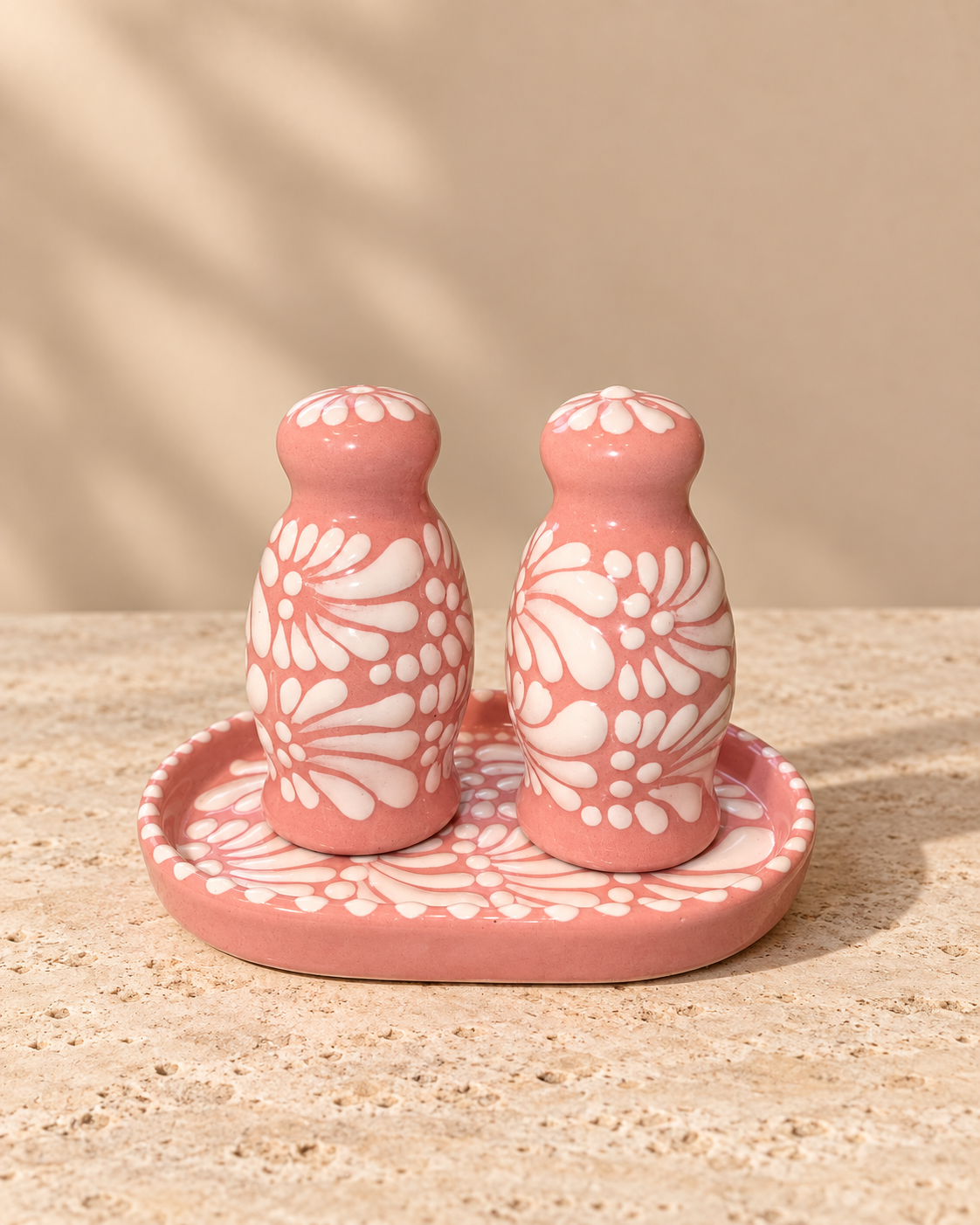 Pink salt and pepper shakers with plate